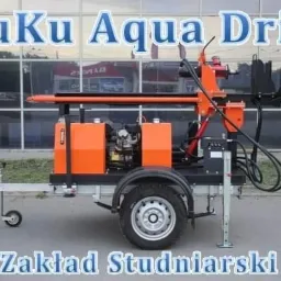 Mobilna wiertnica studni głębinowych 'BuKu Aqua Drill' na przyczepie, Zakład Studniarski, widok z boku na tle budynku.