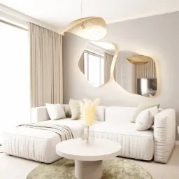 Jasny salon z modułową sofą, okrągłym stolikiem kawowym i dekoracyjnym lustrem z oświetleniem, uzupełniony pampasową trawą w wazonie.