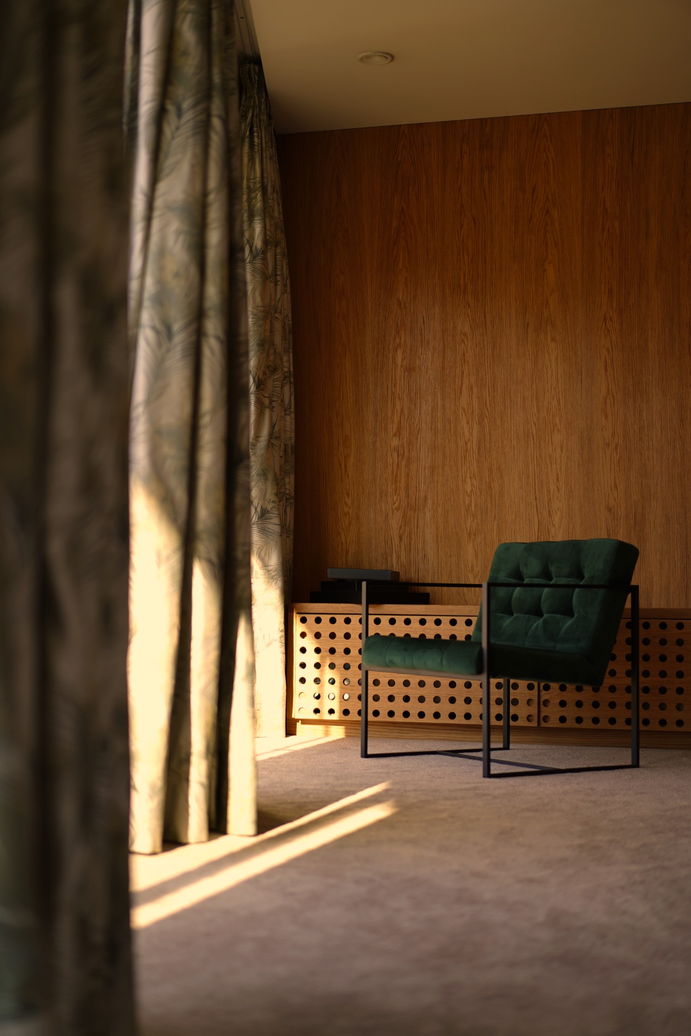 Pokój z drewnianą ścianą, zielonym fotelem z czarną ramą i zasłonami z motywem liści, oświetlony promieniami słońca wpadającymi przez okno.