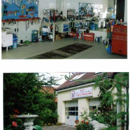 Warsztat z narzędziami na ścianach i garaż z bramą przemysłową, otoczony zielenią i fontanną, z widocznym szyldem informującym o alarmach i telewizji przemysłowej.