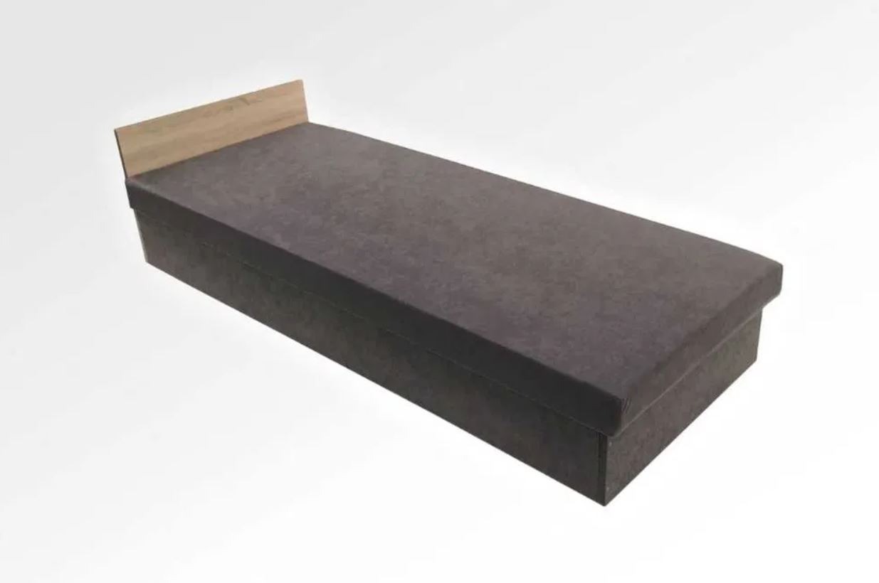 Prosty tapczan z szarą tapicerką i drewnianym zagłówkiem na białym tle, widziany z perspektywy góry.