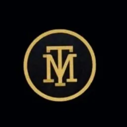 Złote logo TM w czarnym okręgu na ciemnym tle.