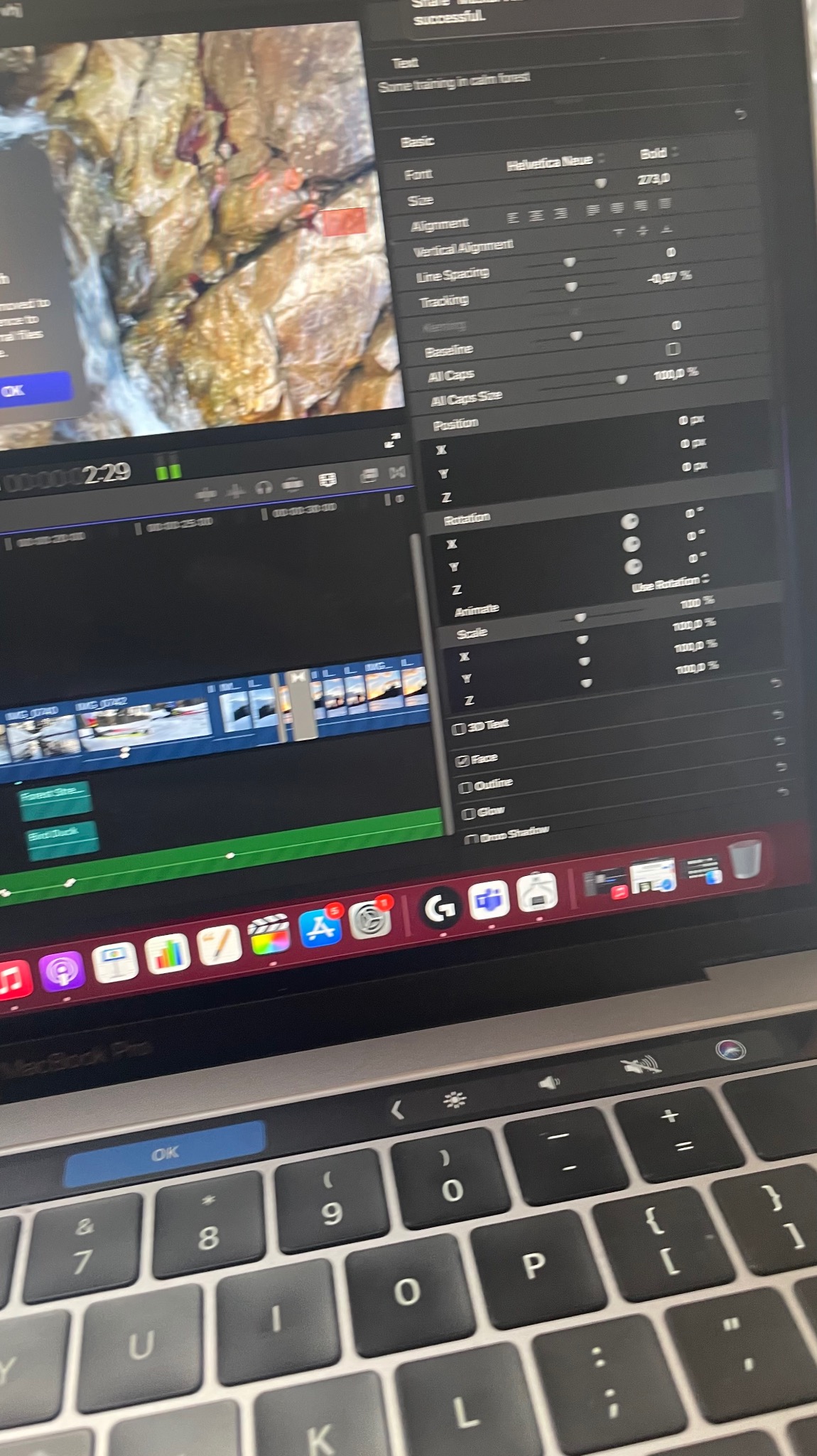 Ekran MacBook Pro z otwartym oprogramowaniem do edycji wideo, widoczny timeline z klipami i okno ustawień tekstu z fontem Helvetica Neue Bold ustawionym na 273pt.