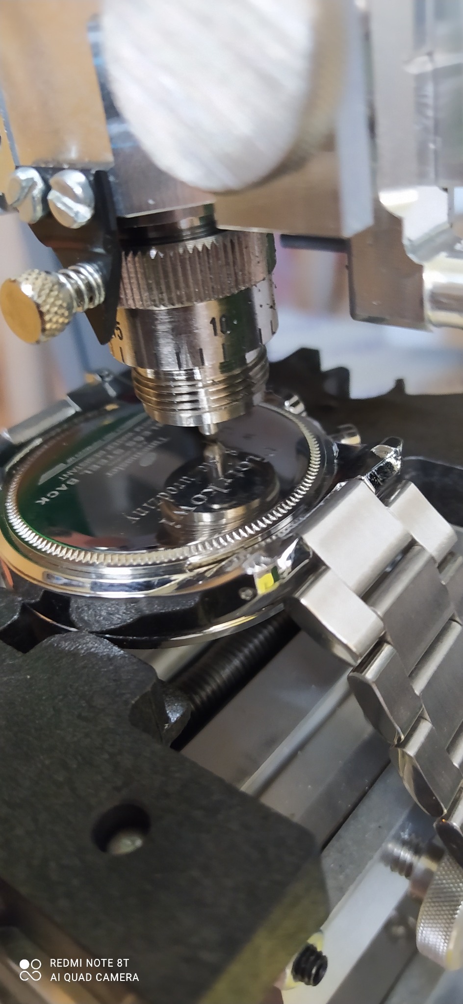 Grawerowanie napisu '...urodziny dla Kowala...' na deklu zegarka za pomocą precyzyjnej maszyny grawerskiej.