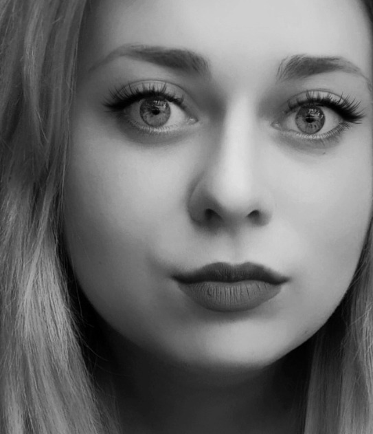 Portret kobiety z przedłużonymi rzęsami i pomalowanymi ustami w odcieniu ciemnej czerwieni, zdjęcie czarno-białe.
