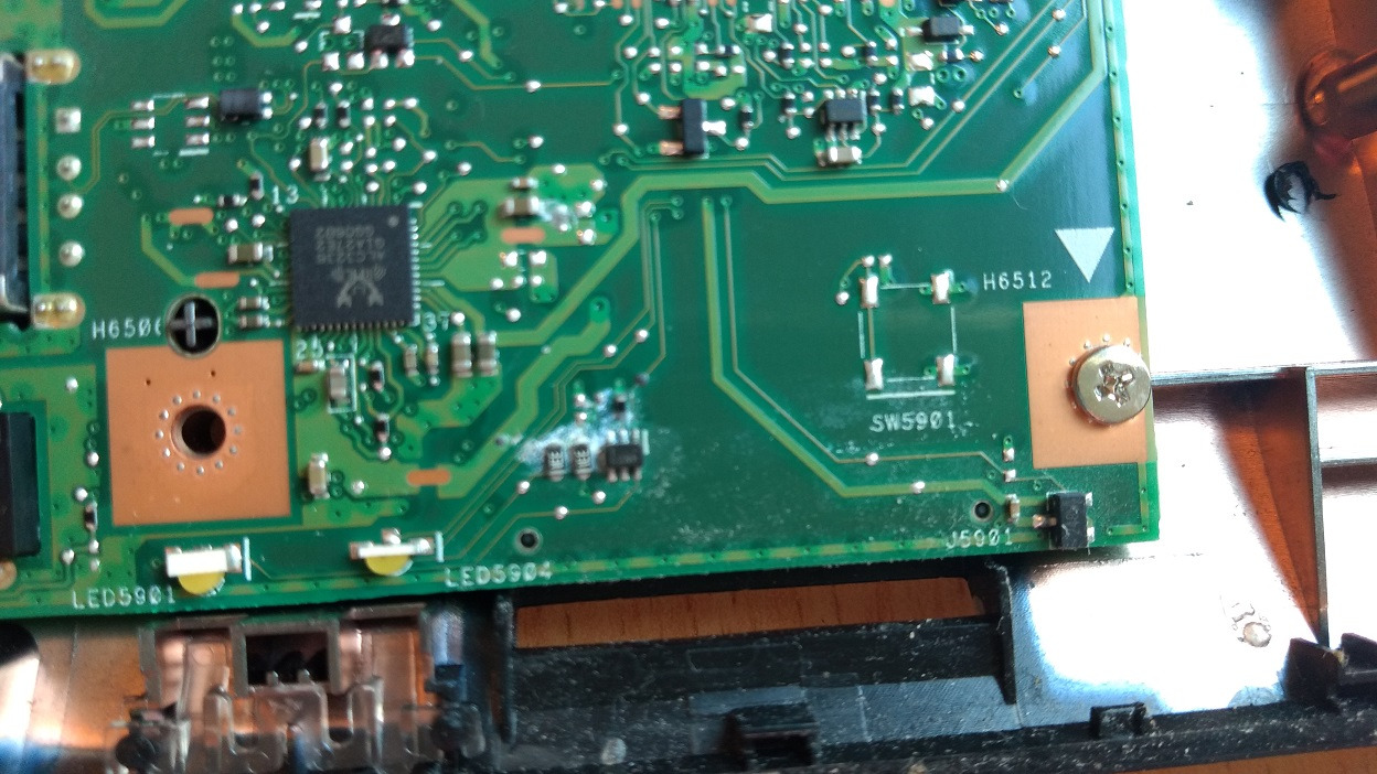 Fragment zielonej płyty głównej laptopa z widocznymi elementami elektronicznymi, śrubką mocującą i oznaczeniami H6506, LED5901, LED5904, SW5901, J5901, H6512.