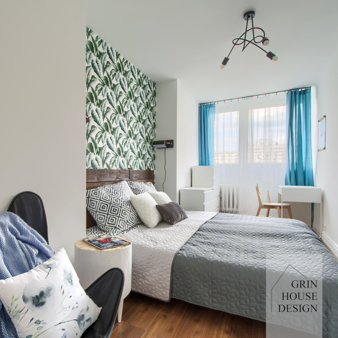 Sypialnia z wzorzystą tapetą z motywem roślinnym.