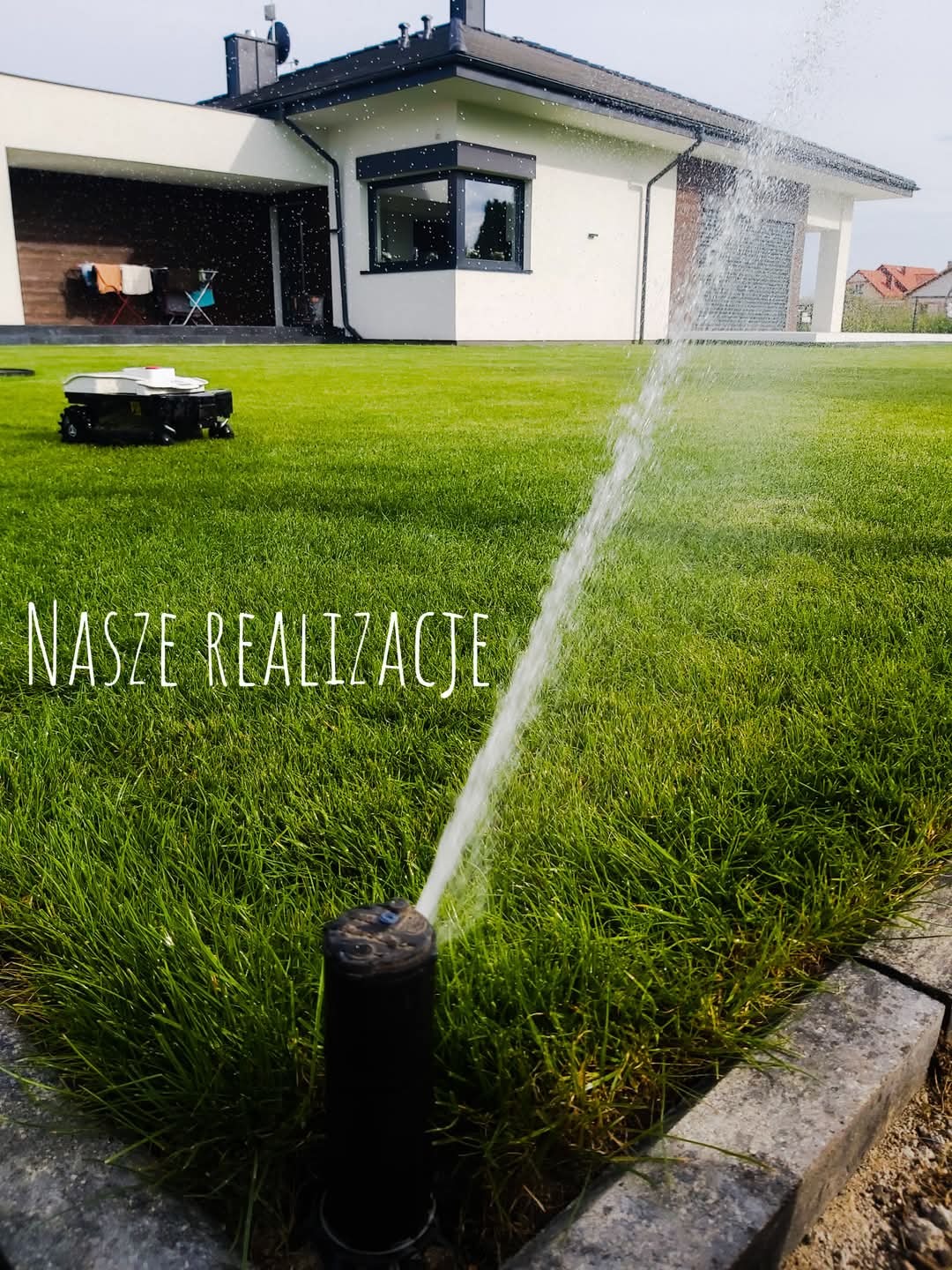 Zraszacz wynurzalny w trakcie pracy na tle zadbanego trawnika, nowoczesnego domu i robota koszącego, z napisem 'Nasze Realizacje'.