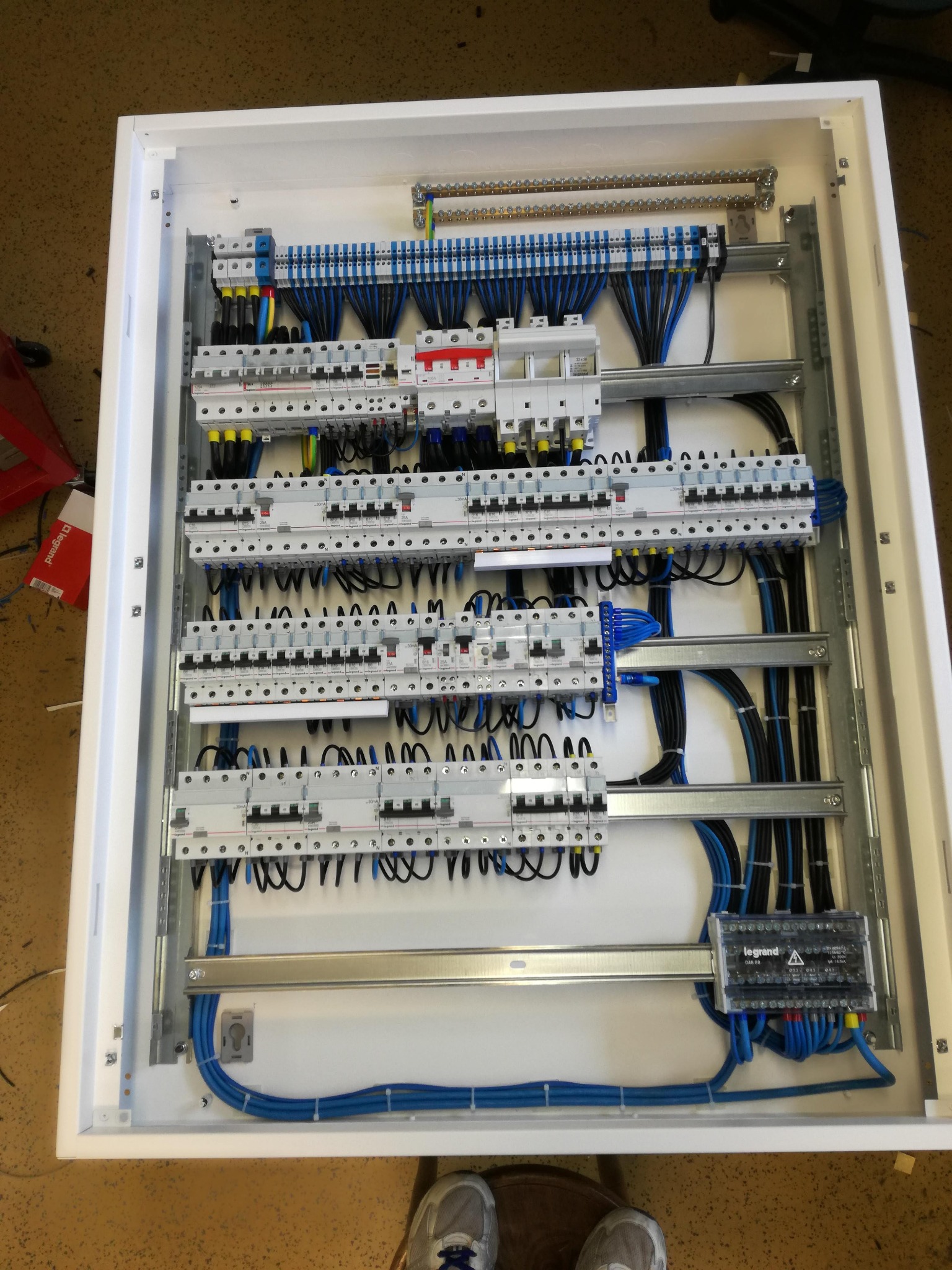 Rozdzielnica elektryczna z zainstalowanymi bezpiecznikami i okablowaniem w estetycznej białej obudowie, widok z góry, instalacja wykonana w Radzyminie.