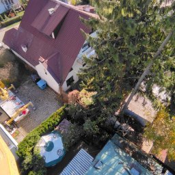 HI-LIFT Patryk Bieniaszewski - Widok z góry na żółty podnośnik koszowy w Lublinie, zaparkowany obok domu z czerwonym dachem, z widocznym drzewem i fragmentem ogrodu.