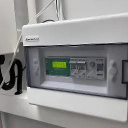 Rozdzielnica elektryczna z wyświetlaczem Sinclair SCM-01 i wyłącznikami Eaton, zamontowana na ścianie, widoczne kable i obudowa Elektro-Plast.