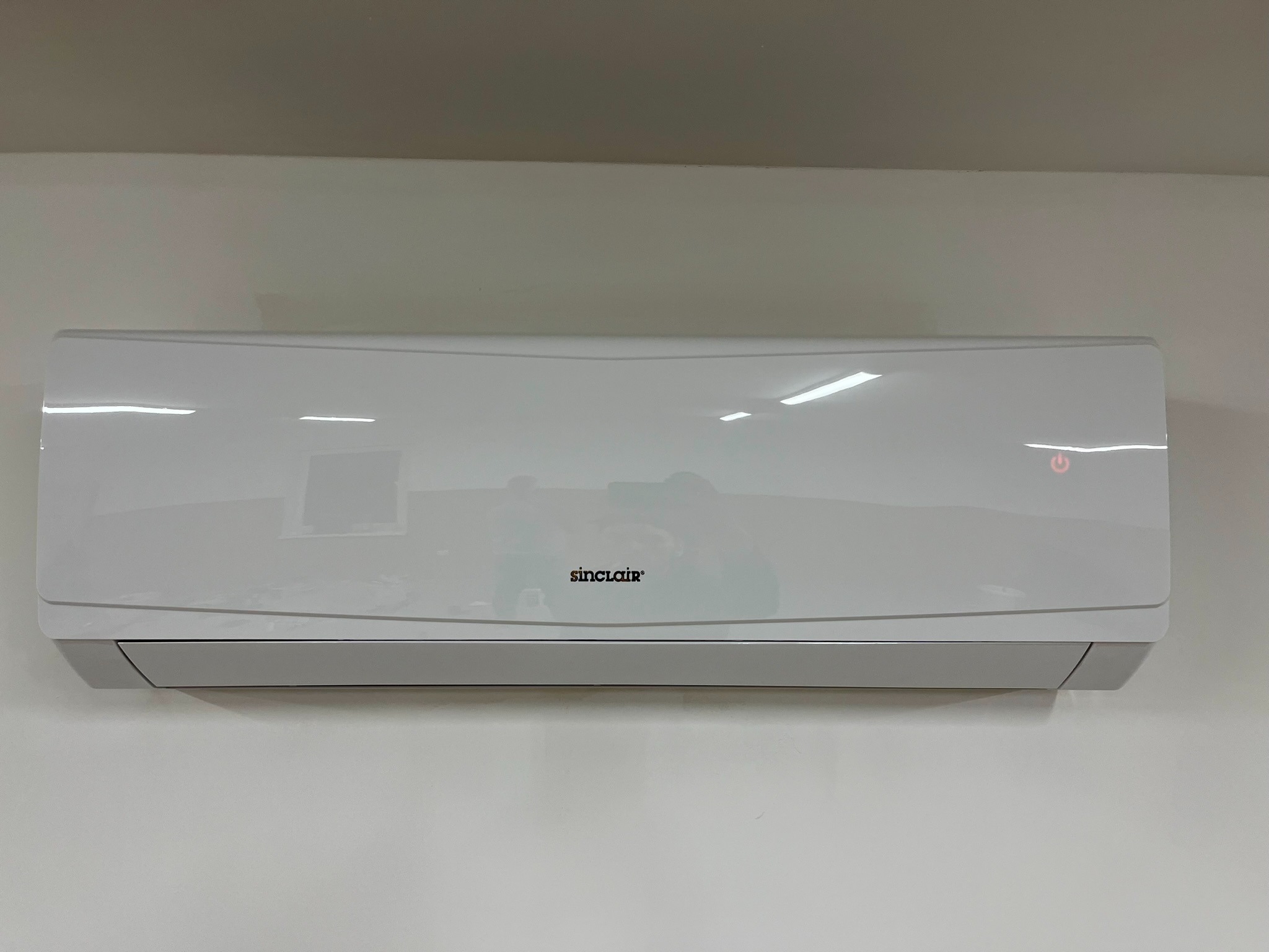 Zamontowana, biała klimatyzacja Sinclair na ścianie w Bielsku Podlaskim, z widoczną diodą sygnalizacyjną w prawym górnym rogu.