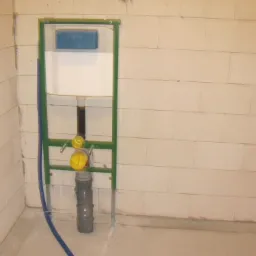 Stelaż podtynkowy WC Viega z widocznymi elementami instalacji hydraulicznymi, w surowym stanie przed zabudową, na tle ściany z białych bloczków.