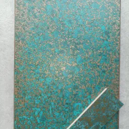 Próbka blatu z efektem patyny w odcieniach turkusu i złota, obok mniejszy fragment z widocznym przekrojem.