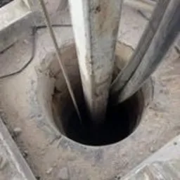 Otwór kominowy z widocznymi przewodami i konstrukcją wsporczą, prawdopodobnie w trakcie frezowania.