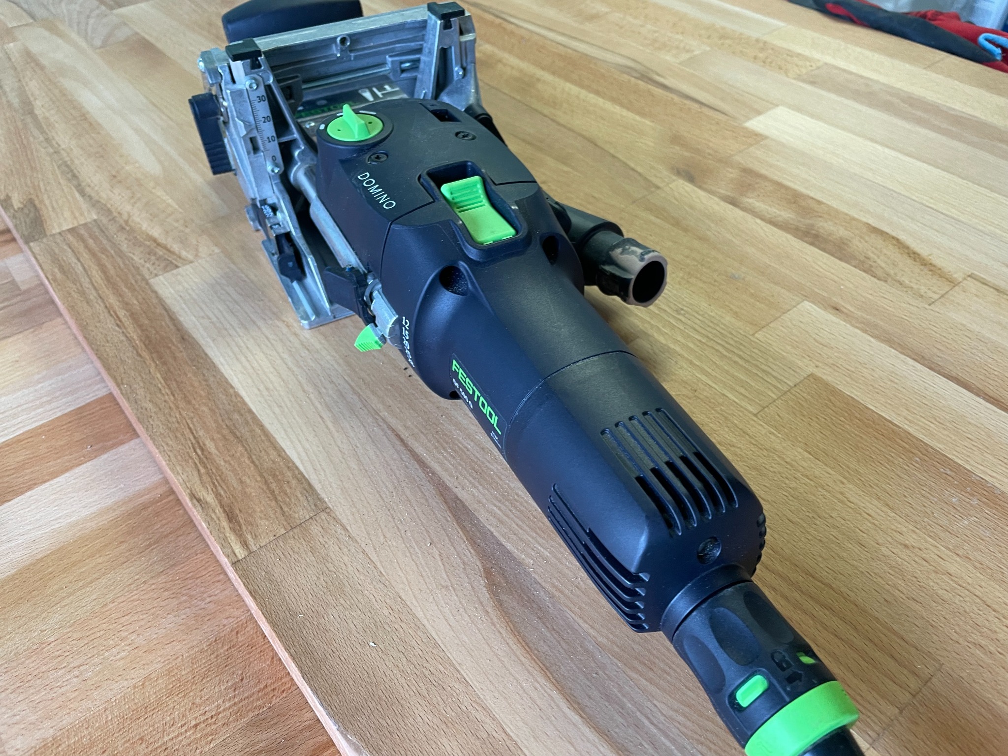 Frezarka do połączeń kołkowych Festool Domino na drewnianym blacie z widocznymi śladami frezowania.