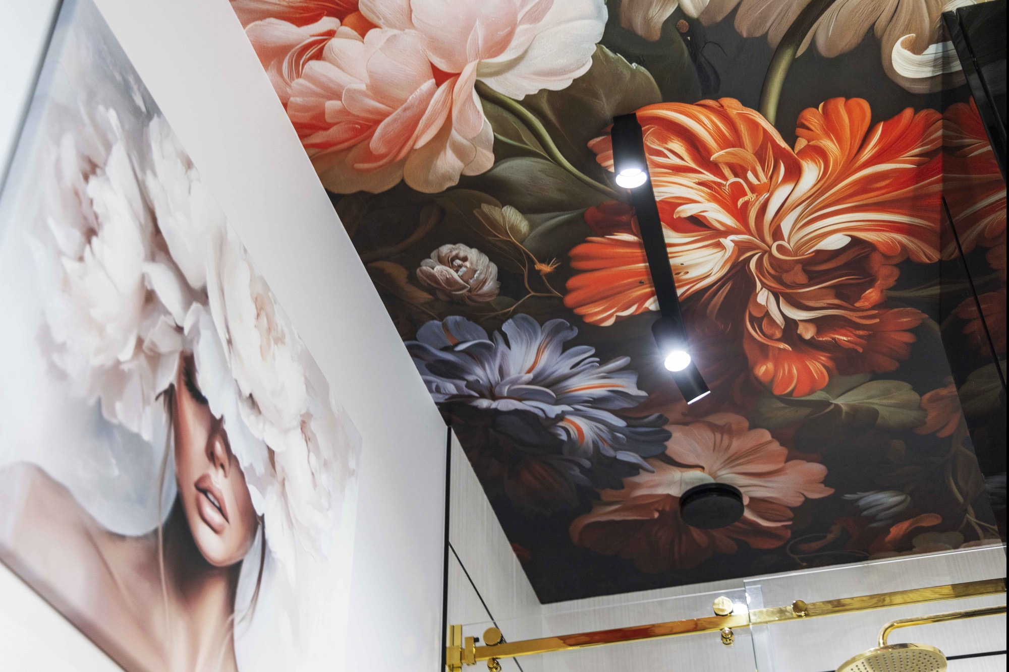 Wnętrze z fototapetą w kwiaty na suficie i obrazem kobiety w kwiatach na ścianie. Nowoczesne oświetlenie punktowe i złote elementy wykończeniowe.