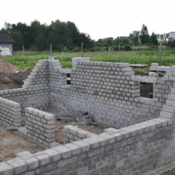 Ściany zewnętrzne piwniczne murowane z bloczka betonowego.