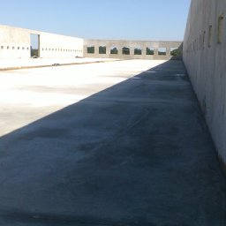 Artur Bąbiak - Surowy stan budowy domu z betonu komórkowego, widoczne ściany z otworami okiennymi i drzwiowymi, wczesna faza budowy, jasne niebo.