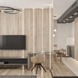 Nowoczesny salon z drewnianą ścianą z podświetleniem LED, szarym stolikiem RTV, biurkiem z laptopem i krzesłem oraz widokiem na jadalnię i kuchnię w tle.