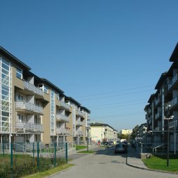 Pracownia Architektoniczna ART-PRO Sp.z.o.o - Nowoczesne budynki wielorodzinne z balkonami, elewacja w odcieniach beżu i brązu, widok z perspektywy ulicy w słoneczny dzień.