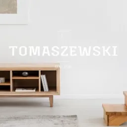 Jasne drewniane schody bez poręczy, ustawione przy białej ścianie obok drewnianej szafki RTV z dekoracjami, minimalistyczne wnętrze z logo firmy Tomaszowski Wood Store w tle.