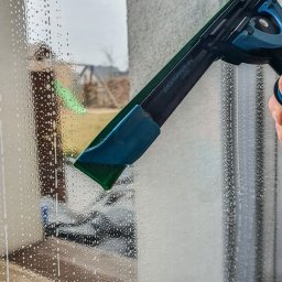 Window's Ninja - Czyszczenie okna z użyciem ściągaczki Liqudator S.L., widoczne krople wody na szybie i częściowo oczyszczona powierzchnia.