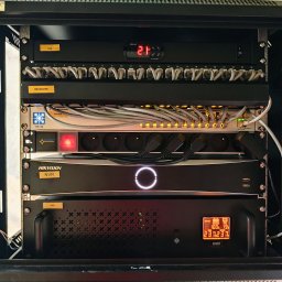 Szafa Rack wisząca wyposażona w panel chłodzący z wbudowanym termostatem, patch panel, organizer kablowy, switch poe, listwa zasilająca, rejestrator CCTV, UPS.
