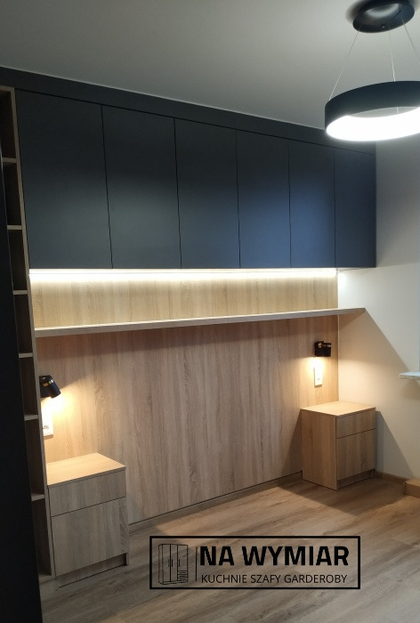 Ciemnoszare szafy na wymiar pod sufitem z oświetleniem LED nad drewnianym panelem ściennym i szafkami nocnymi w sypialni, oświetlenie sufitowe w kształcie pierścienia.