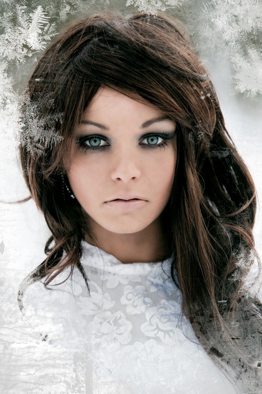 Portret kobiety z intensywnym makijażem oczu i długimi, ciemnymi włosami, na tle z efektem mrozu.