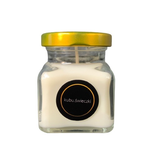 Kwadratowa szklana świeca w słoiczku z złotą nakrętką i czarną etykietą z napisem 'kubu.świeczki'.