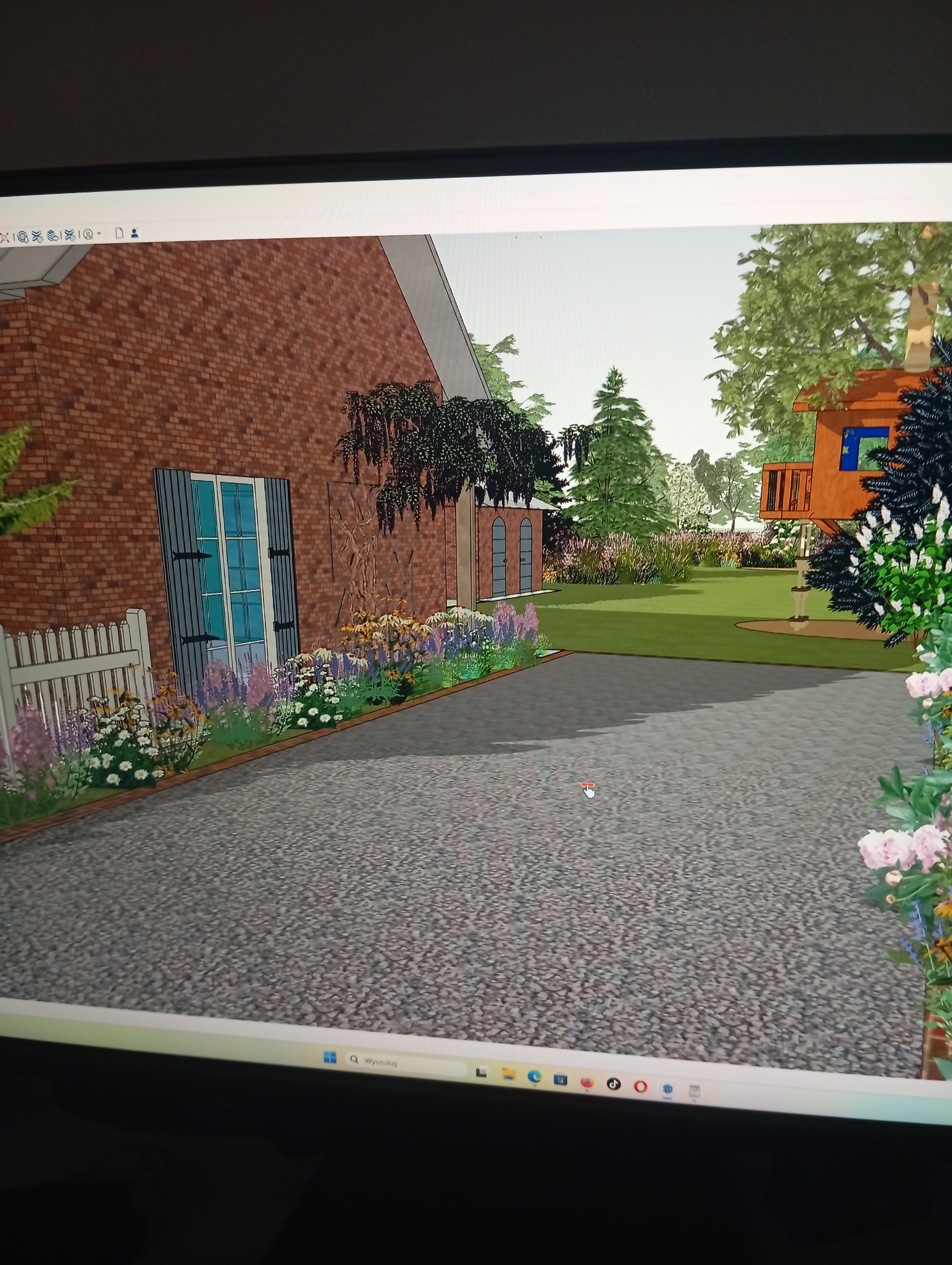 Wizualizacja 3D projektu ogrodu w Strzyżowie. Widok na dom z cegły, rabaty kwiatowe wzdłuż ścieżki, drzewa i domek na drzewie w tle. Prezentacja koncepcji zagospodarowania przestrzeni.