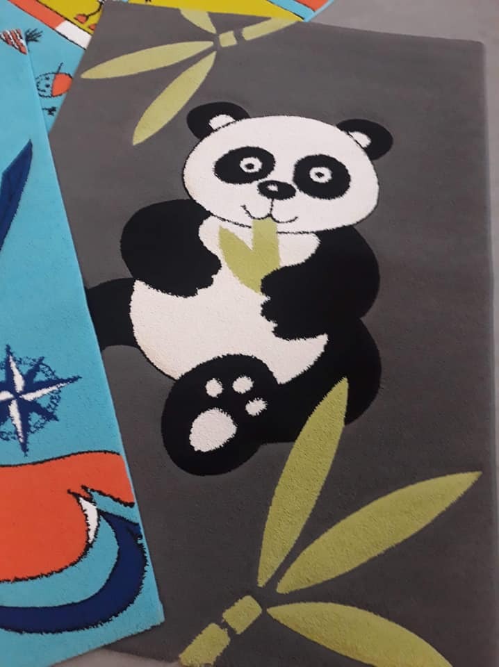 Dwa dywany dziecięce: szary z pandą trzymającą bambusa i błękitny z motywami morskimi, leżące obok siebie.