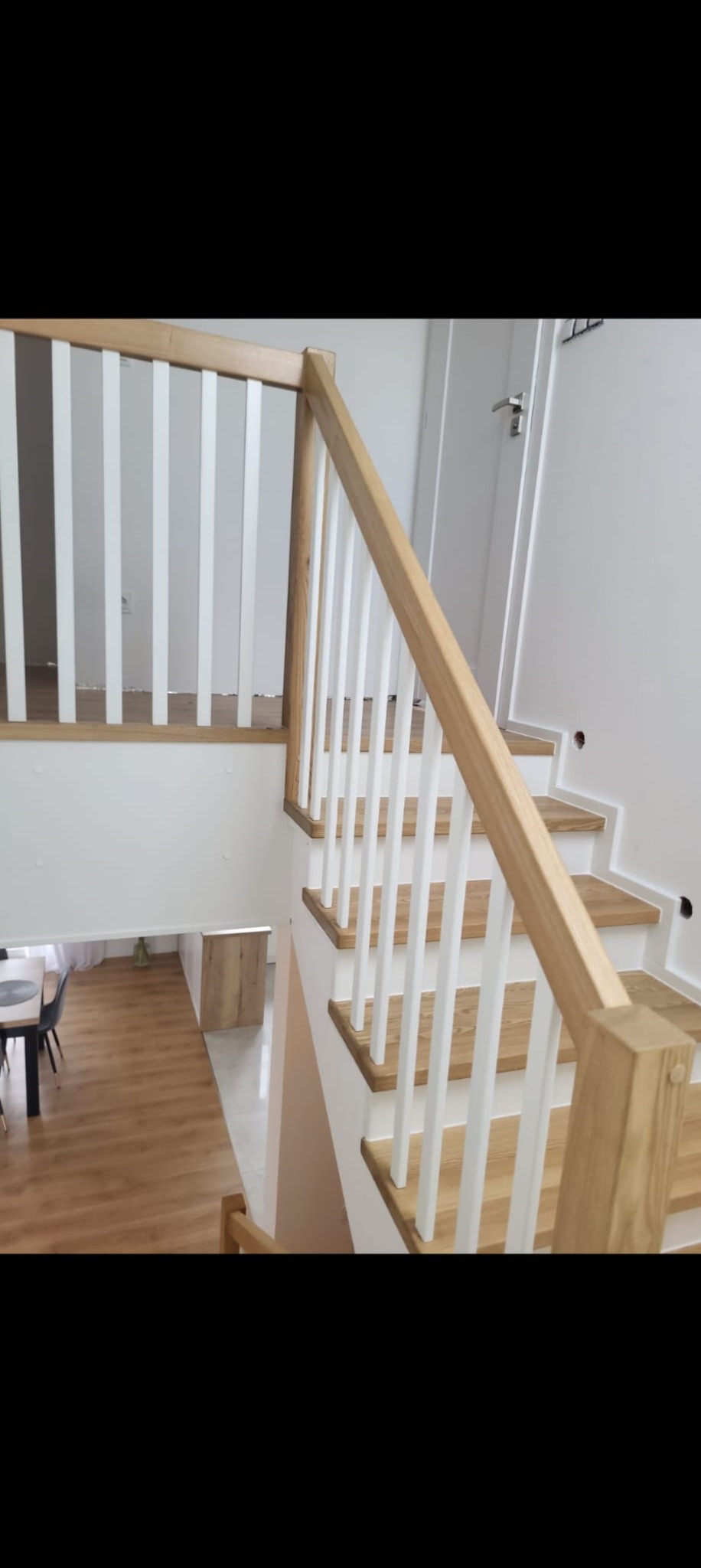 Jasne schody z drewnianymi stopniami i białymi balustradami, widok z góry, minimalistyczny design, nowoczesne wykończenie wnętrza.