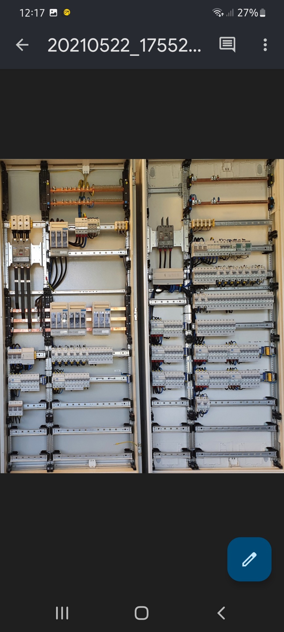 Dwie rozdzielnice elektryczne w metalowych obudowach, widoczne liczne kable, bezpieczniki i inne elementy instalacji elektrycznej, ułożone symetrycznie na szynach DIN.