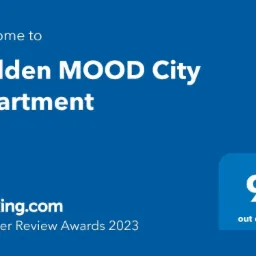 Niebieska grafika z tekstem 'Welcome to Golden MOOD City Apartment', logo Booking.com Traveller Review Awards 2023 oraz oceną 9 na 10.