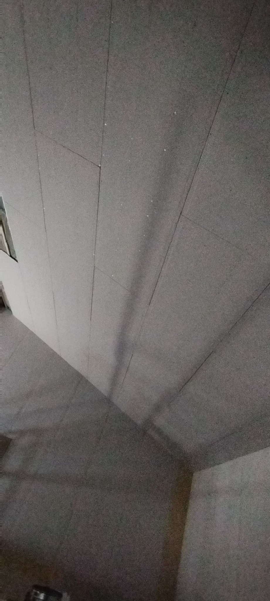 Szare płyty gipsowo-kartonowe na suficie, widoczne łączenia, przygotowane do dalszych prac wykończeniowych.