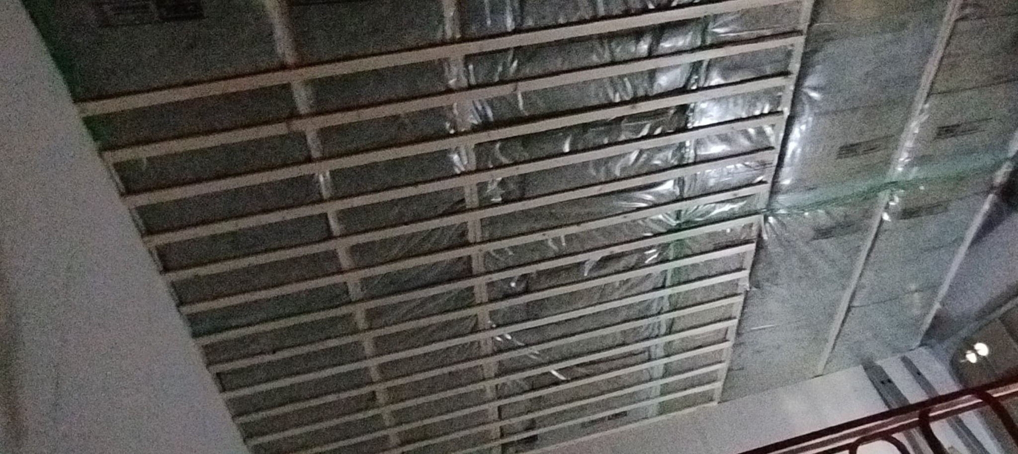 Konstrukcja metalowa podwieszanego sufitu z izolacją termiczną, widok z dołu, etap montażu.