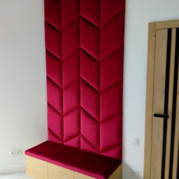 Marek Krajnik - Panel ścienny z siedziskiem w kolorze fuksji, geometryczny wzór, wykonany na wymiar w Piastowie. Obok widoczna drewniana, nowoczesna stolarka drzwiowa.