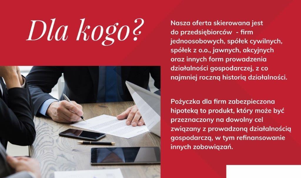 Osoba w garniturze podpisuje dokument na drewnianym stole, obok leżą dwa smartfony i długopis.