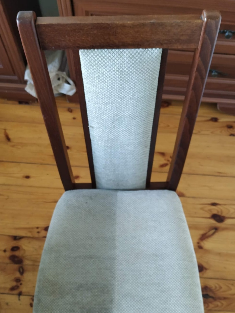 Krzesło z tapicerowanym siedziskiem w Łążynie, widoczne po połowie wyczyszczone siedzisko, ukazujące różnicę przed i po zabiegu.