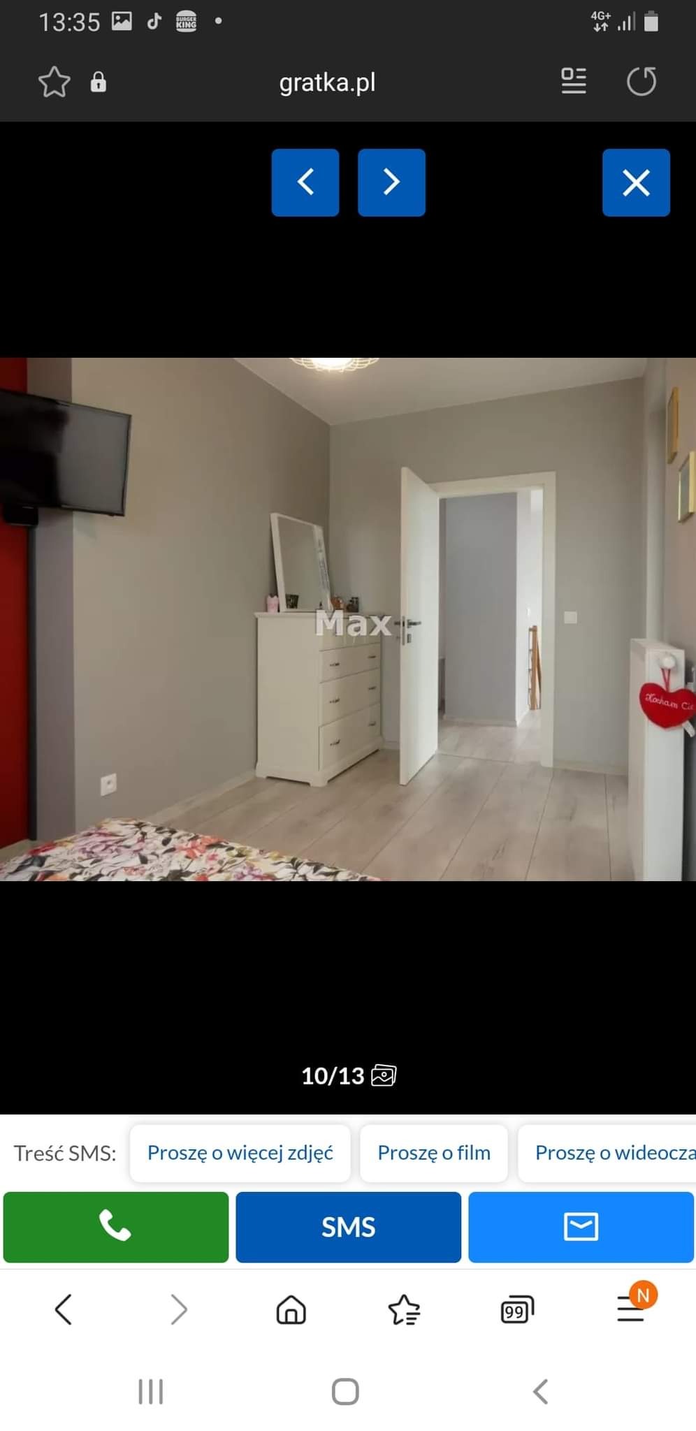 Jasne wnętrze pokoju po remoncie z szarą ścianą, białym parkietem i komodą z lustrem, widok na otwarte drzwi do kolejnego pomieszczenia.