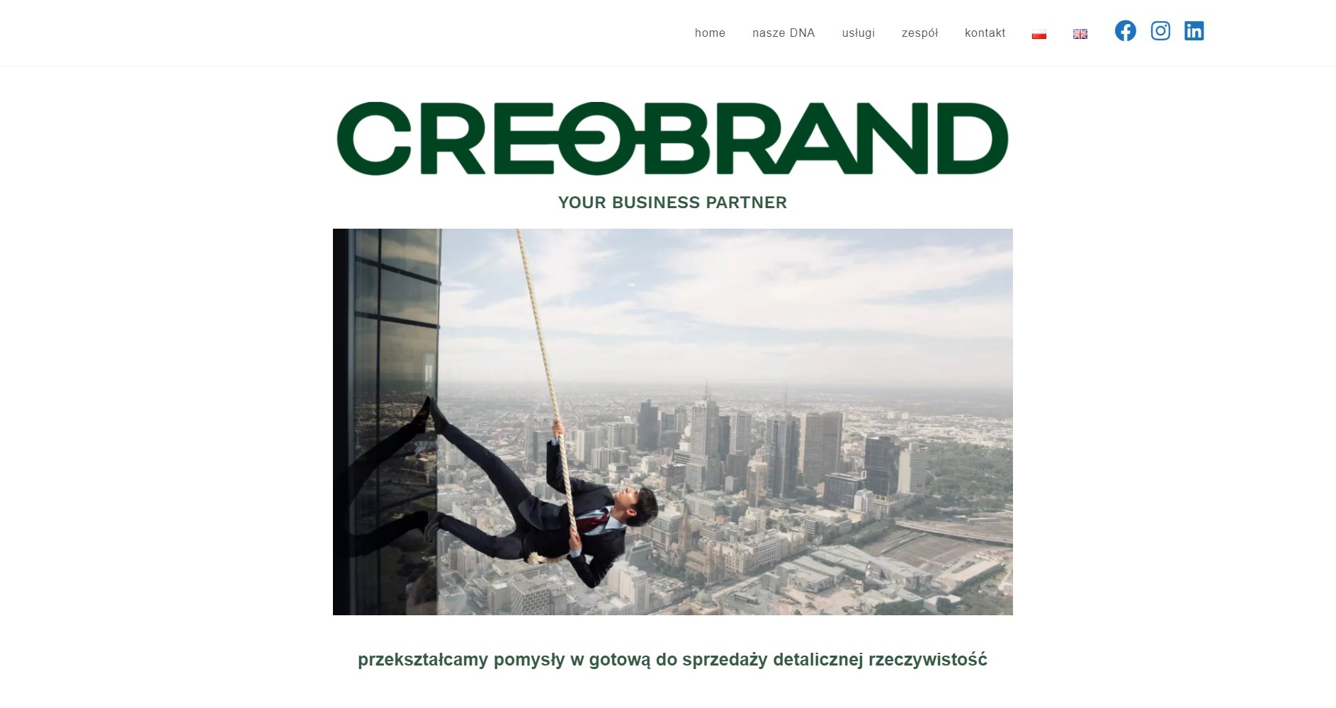 Strona internetowa firmy Creobrand z ilustracją biznesmena w garniturze zjeżdżającego na linie z wieżowca na tle panoramy miasta.