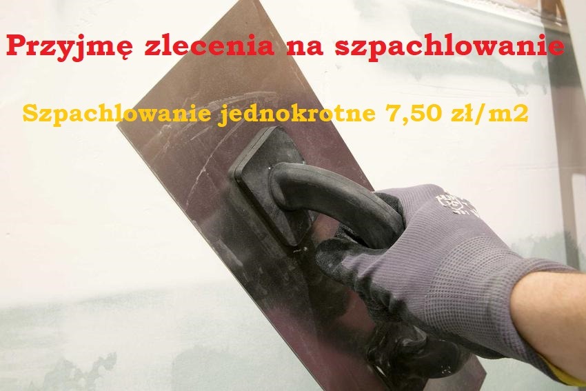 Ręka w rękawicy operuje pacą podczas prac wykończeniowych ścian w Białymstoku. Na ścianie widoczne napisy reklamujące usługę.