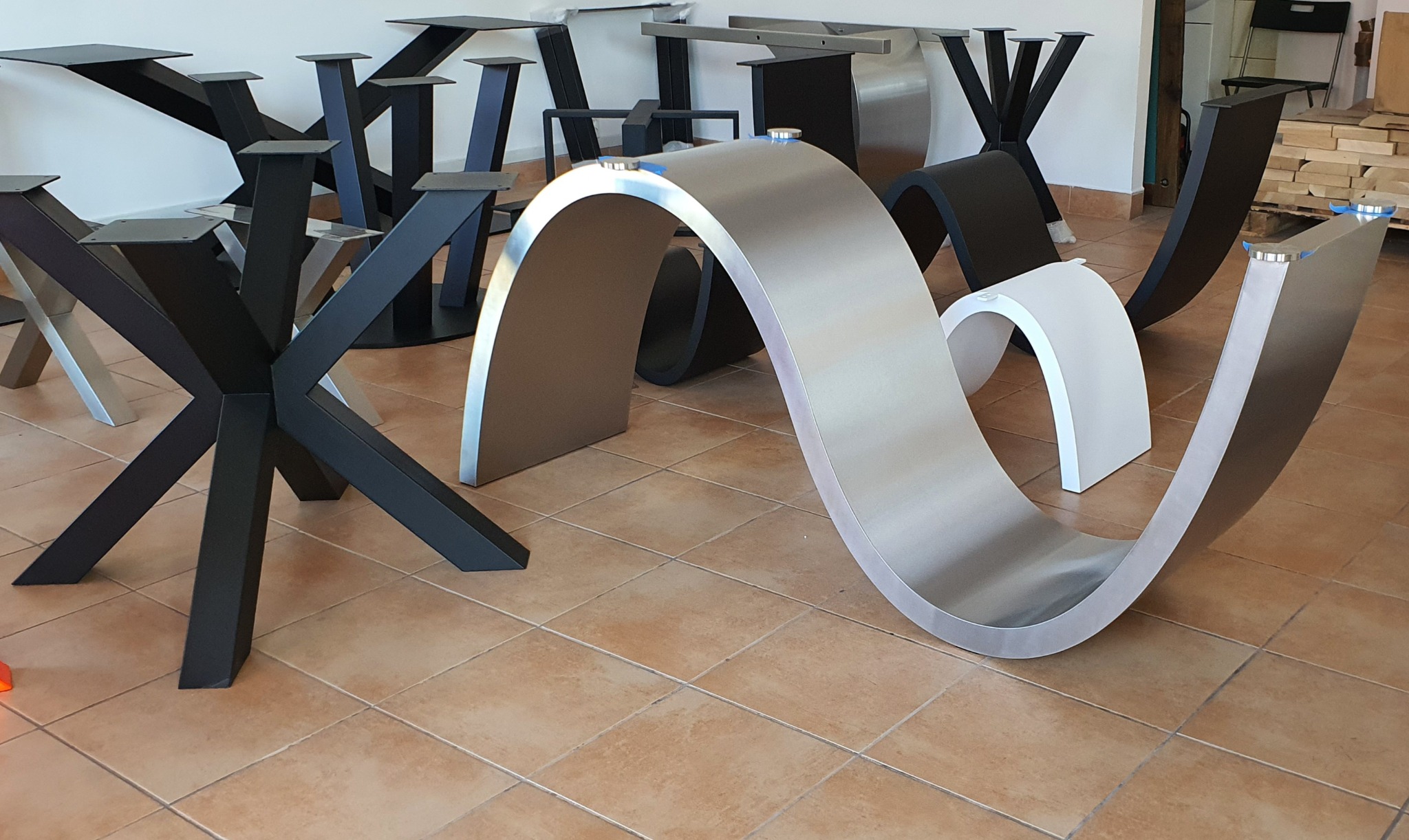 Metalowe nogi do stołów o różnych kształtach: krzyżowe, łukowe. Nogi w kolorach czarnym, srebrnym i białym. Prezentacja różnych stylów i wzorów nóg do stołów.