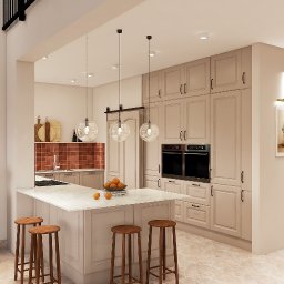 Emilia Kozłowska Projekty z Pasją - Jasna kuchnia z wyspą i hokerami. Nad wyspą wiszą trzy szklane lampy. W tle zabudowa kuchenna z piekarnikami i płytkami na ścianie.