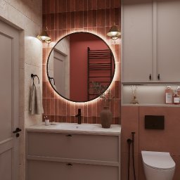 Emilia Kozłowska Projekty z Pasją - Nowoczesna łazienka z okrągłym lustrem podświetlanym LED, brązowymi płytkami i beżową szafką pod umywalką. Minimalistyczny design z akcentami w stylu retro.