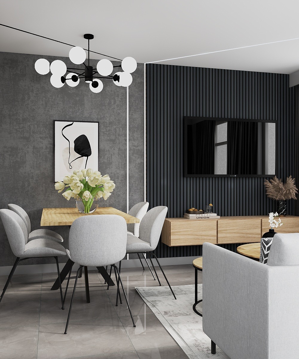 Elegancka jadalnia z drewnianym stołem, szarymi krzesłami i nowoczesnym oświetleniem. Na ścianie abstrakcyjny obraz i telewizor. Minimalistyczny design.