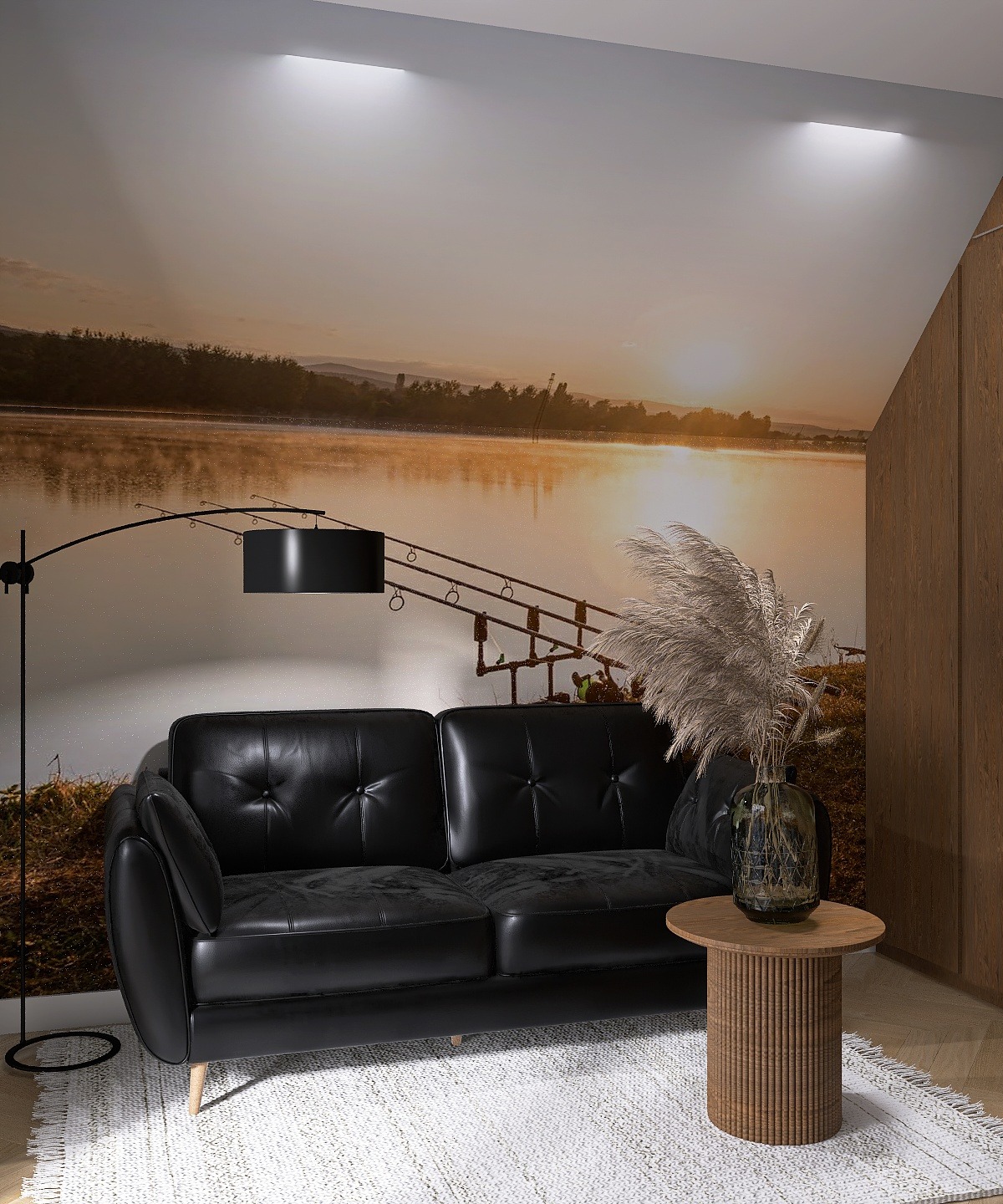 Czarna sofa na tle fototapety z motywem jeziora o zachodzie słońca, uzupełniona lampą łukową i stolikiem z wazonem trawy pampasowej, tworzy przytulną aranżację.