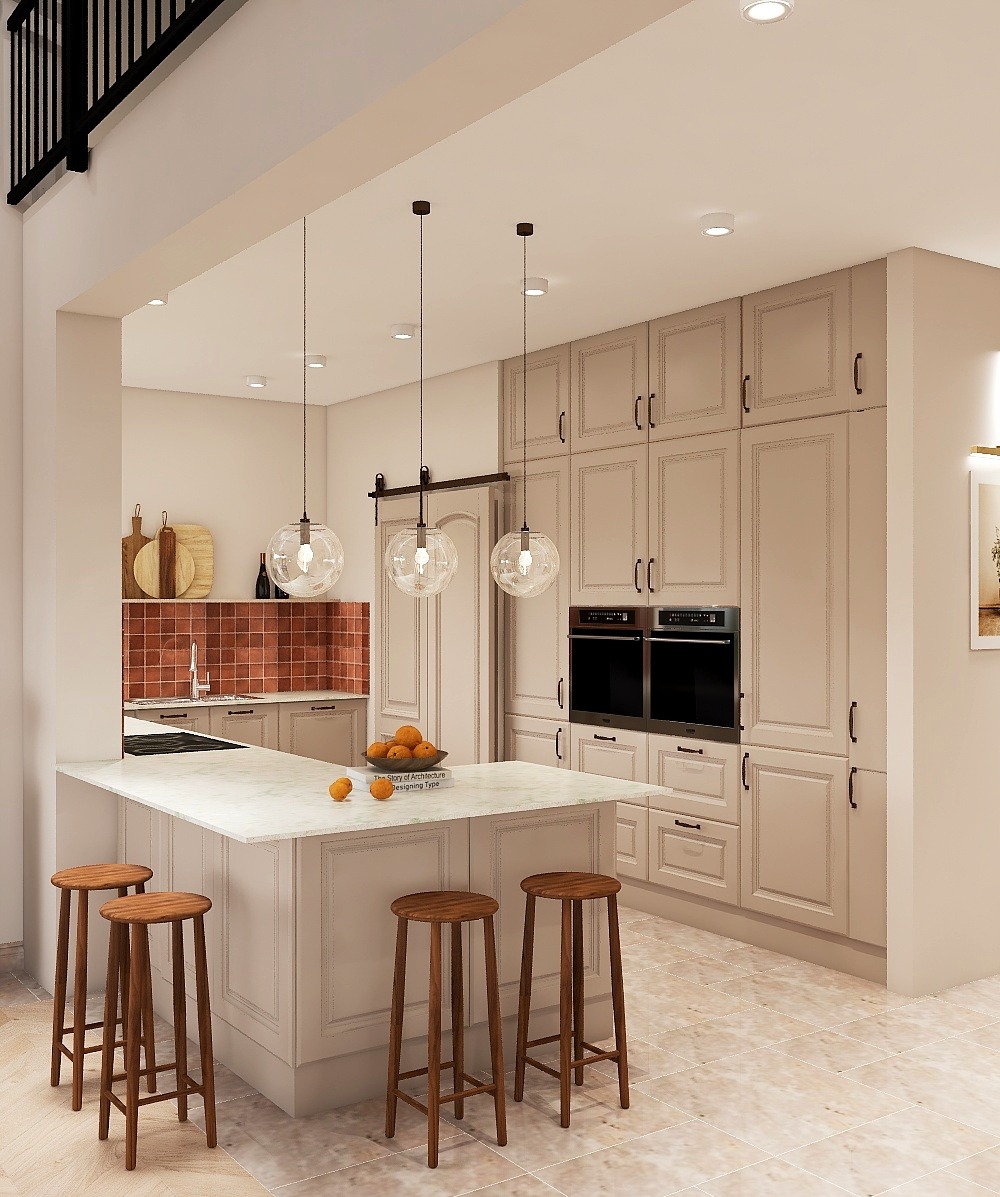 Jasna kuchnia z wyspą i hokerami. Nad wyspą wiszą trzy szklane lampy. W tle zabudowa kuchenna z piekarnikami i płytkami na ścianie.